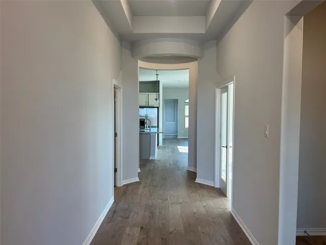 a view of a hallway with wooden floor