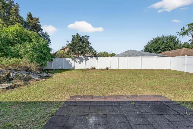a view of a house with a backyard and a tree