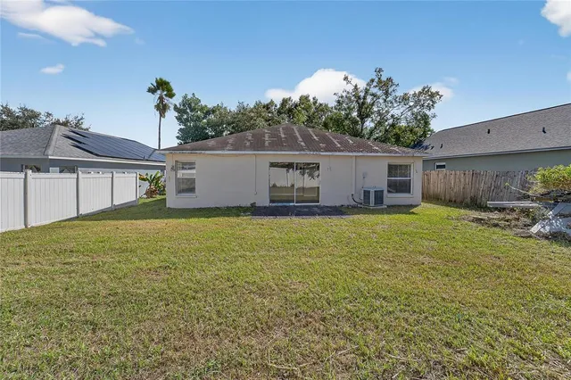 a view of a livingroom with a ceiling fan a kitchen space and a ceiling fan