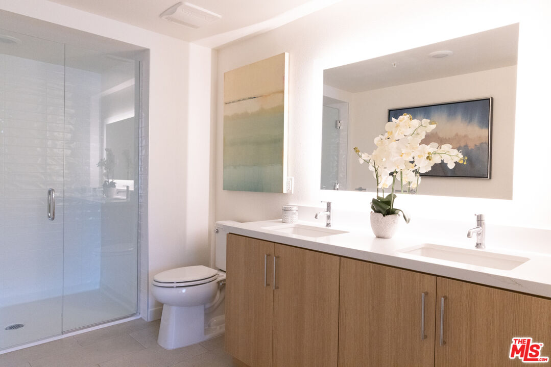 7566 West Sunset Boulevard, Unit 411PHE Los Angeles, CA 90046 - Photo 7 of 15 a bathroom with a toilet sink and mirror