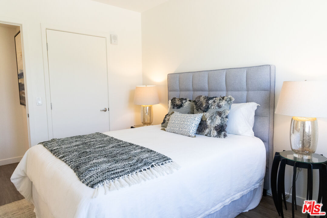 7566 West Sunset Boulevard, Unit 411PHE Los Angeles, CA 90046 - Photo 10 of 15 a large bed in a bedroom next to a lamp