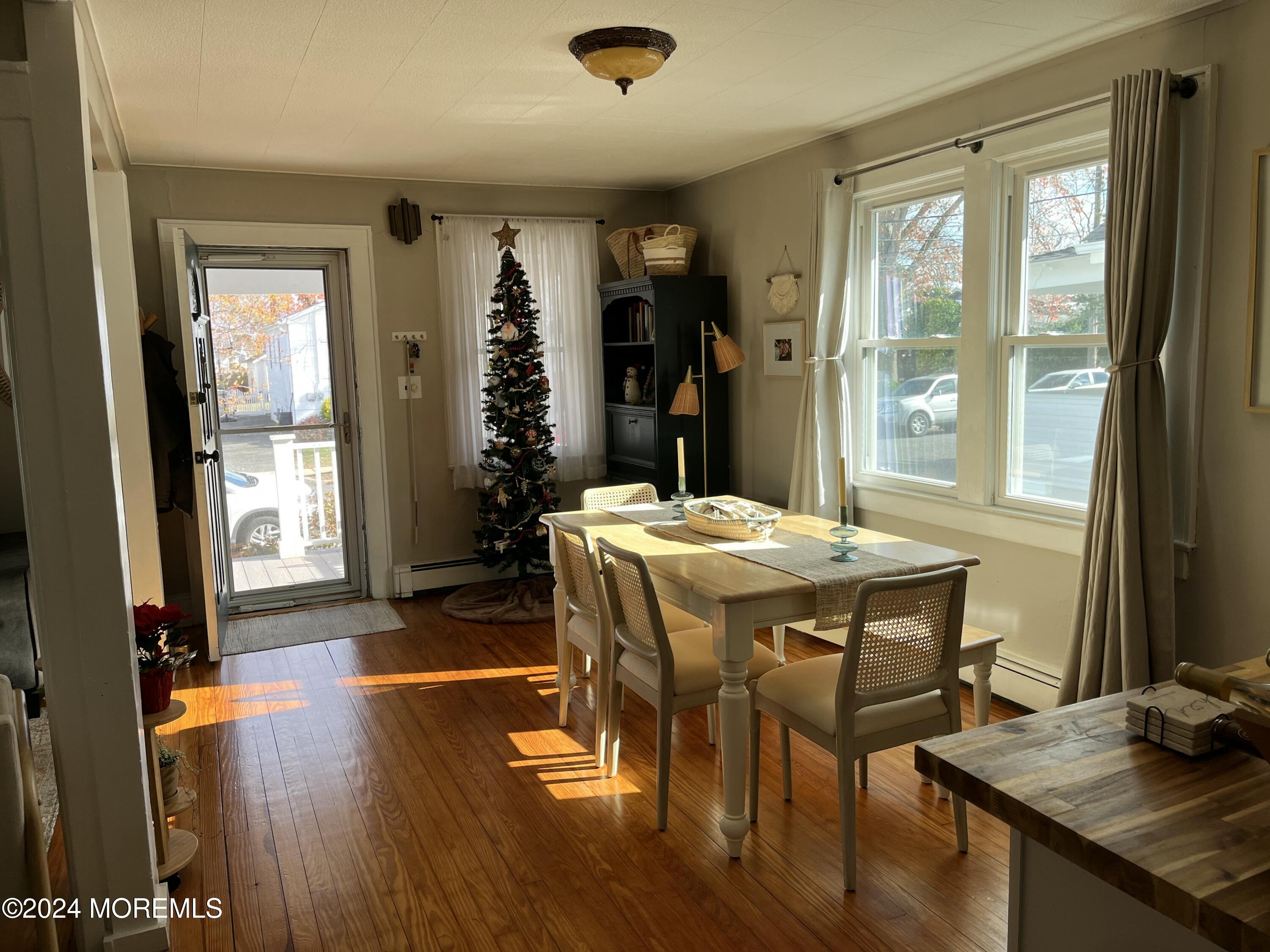1236 Maplewood Road Belmar, NJ 07719 - Photo 7 of 38 a dining room with a table chairs and a flat screen tv