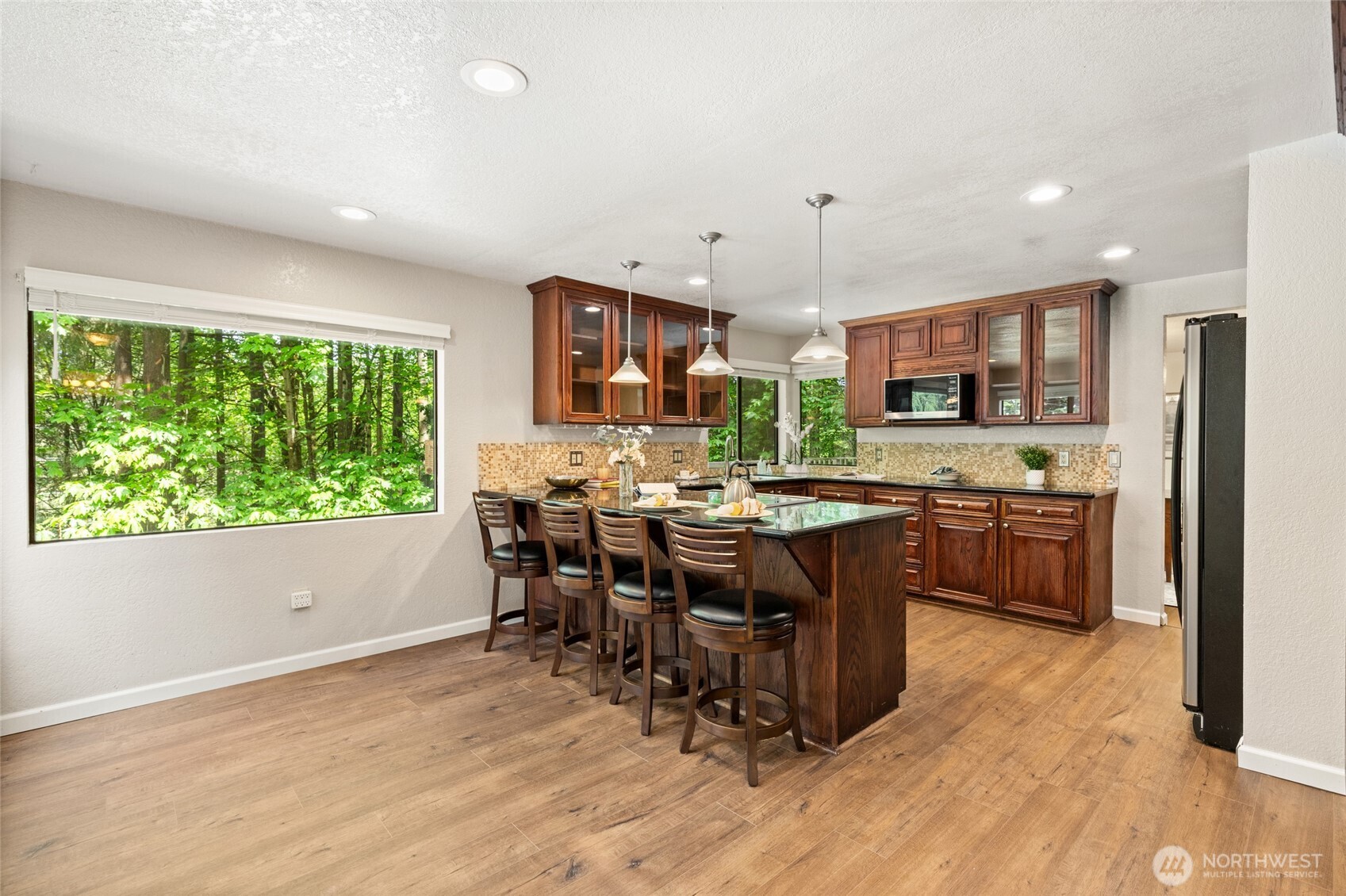 20817 29th Avenue Southeast Bothell, WA 98021 - Photo 8 of 40 a kitchen with a table chairs microwave and refrigerator