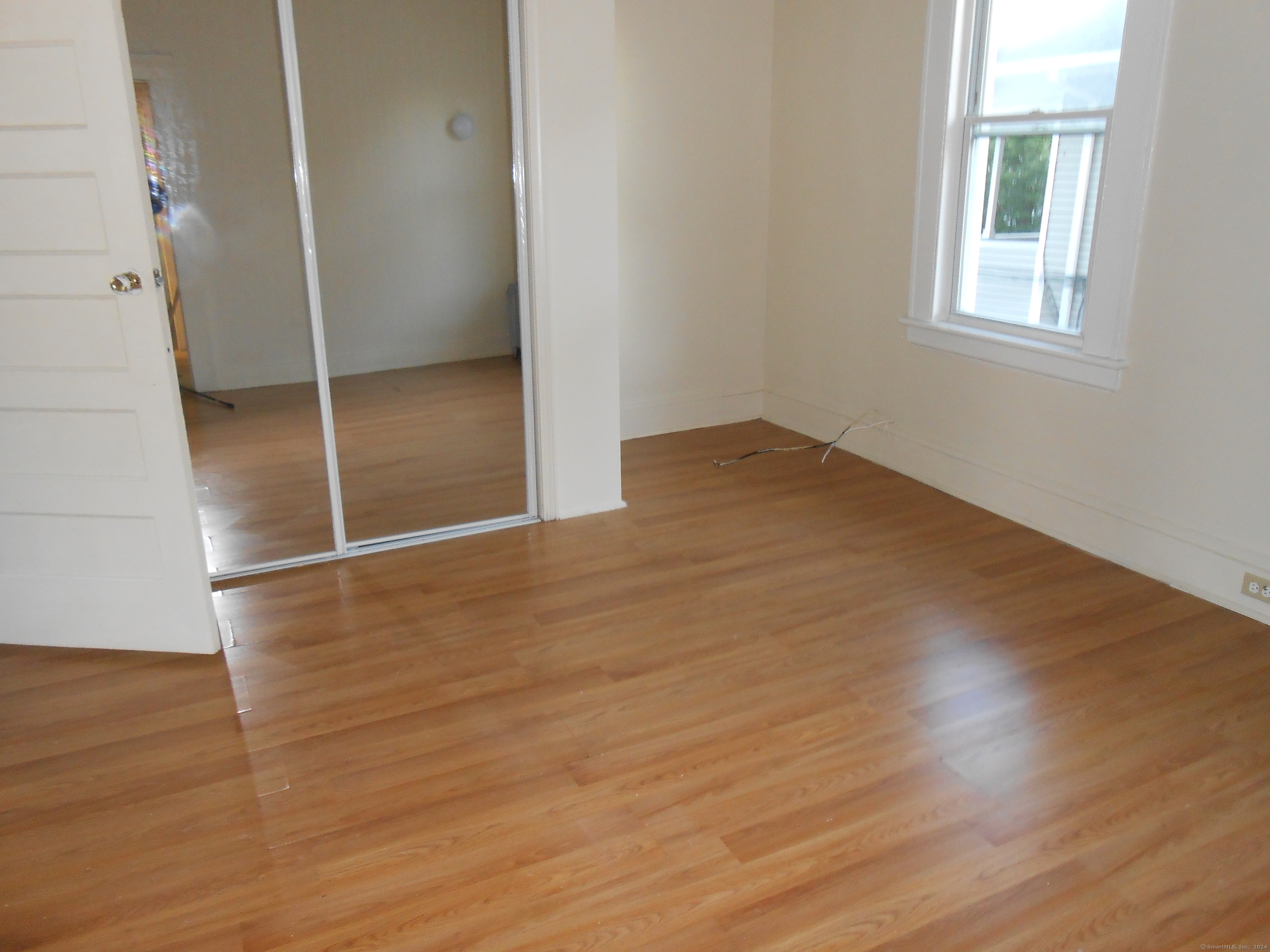 1908 North Avenue Bridgeport, CT 06604 - Photo 2 of 4 an empty room with wooden floor and windows