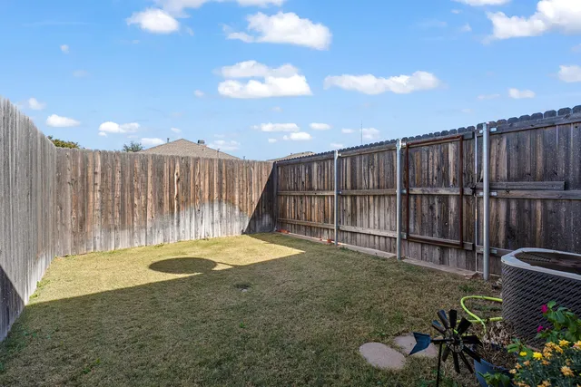 a view of backyard with wooden fence