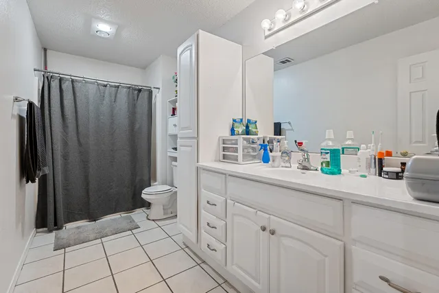 a bathroom with a double vanity sink toilet and shower