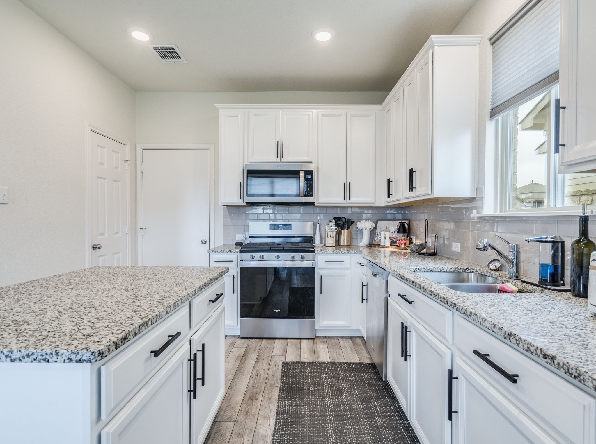 624 Pepperbark Loop Buda, TX 78610 - Photo 11 of 32 a kitchen with stainless steel appliances granite countertop a stove sink and cabinets