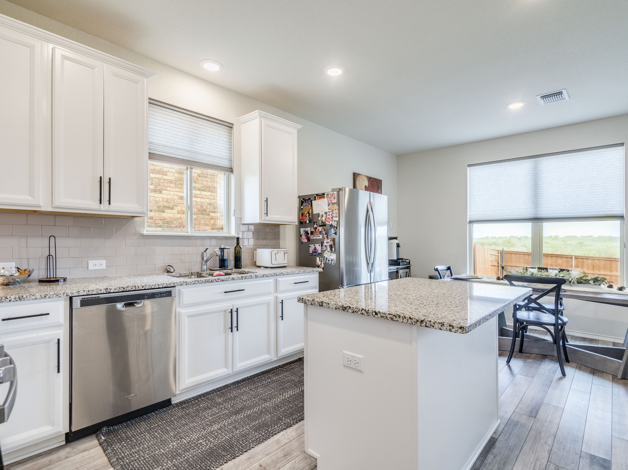 624 Pepperbark Loop Buda, TX 78610 - Photo 10 of 32 a open kitchen with kitchen island granite countertop a sink and white cabinets