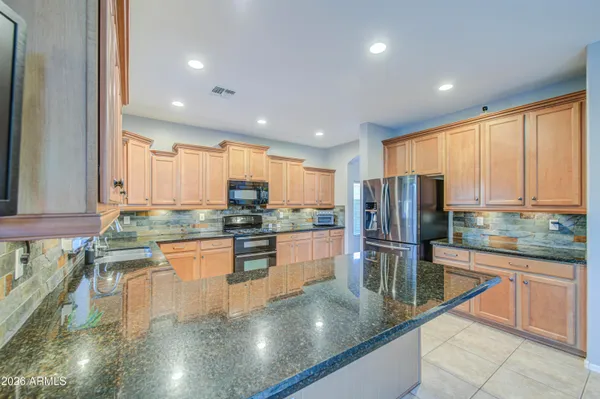 a kitchen with stainless steel appliances granite countertop a stove a sink and a white cabinets