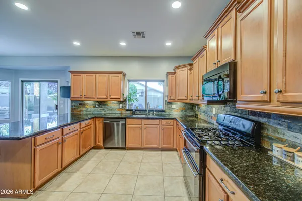 a large kitchen with kitchen island a sink stainless steel appliances and cabinets