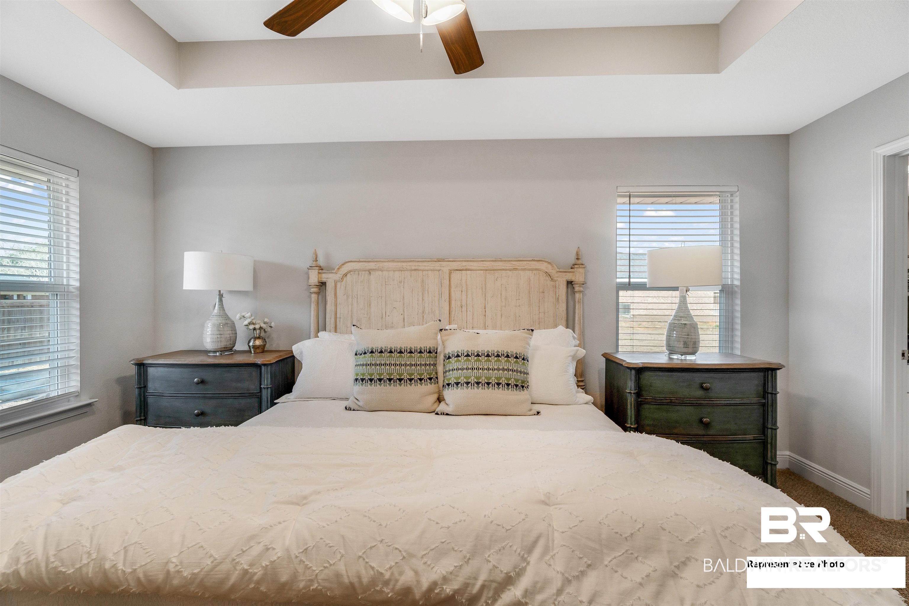 643 Mayflower Drive Foley, AL 36535 - Photo 28 of 34 Carpeted bedroom with a ceiling fan, a tray ceiling, multiple windows, and baseboards