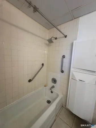 a bathroom with a shower a bath tub and a shower