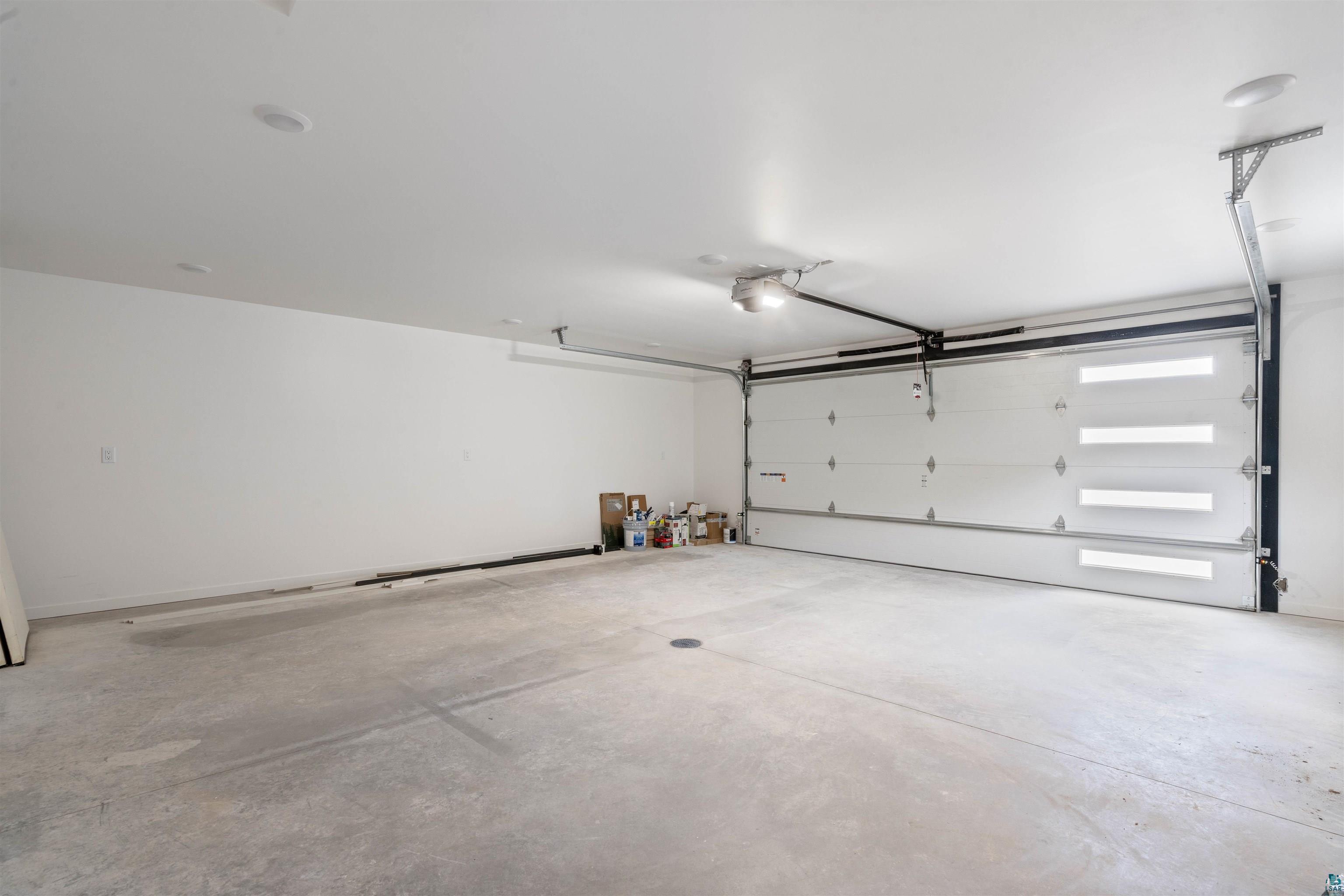 1386 Stephen Road Cloquet, MN 55720 - Photo 24 of 25 Spacious garage featuring a concrete floor, white walls, and a modern garage door with frosted glass panels