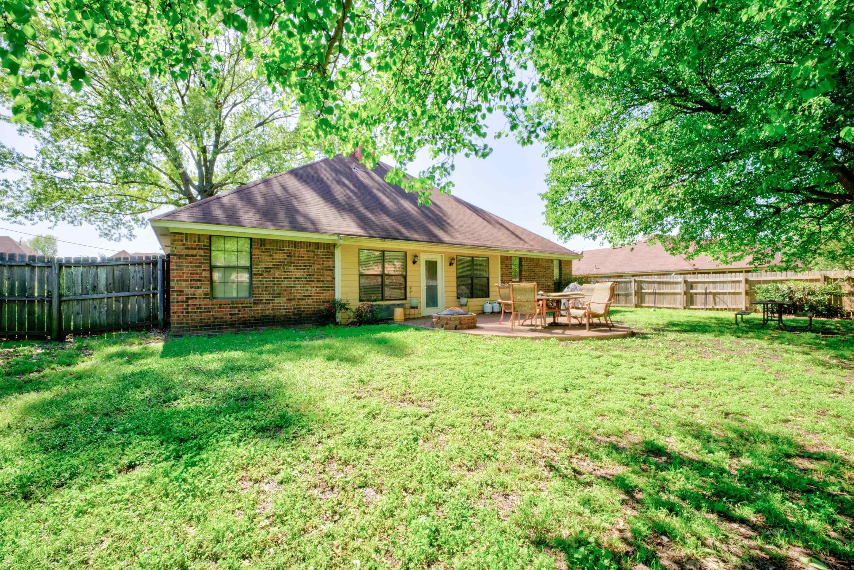 5382 Ross Road Memphis, TN 38141 - Photo 25 of 27 Rear view of property with brick siding, a fenced backyard, a patio area, and a lawn