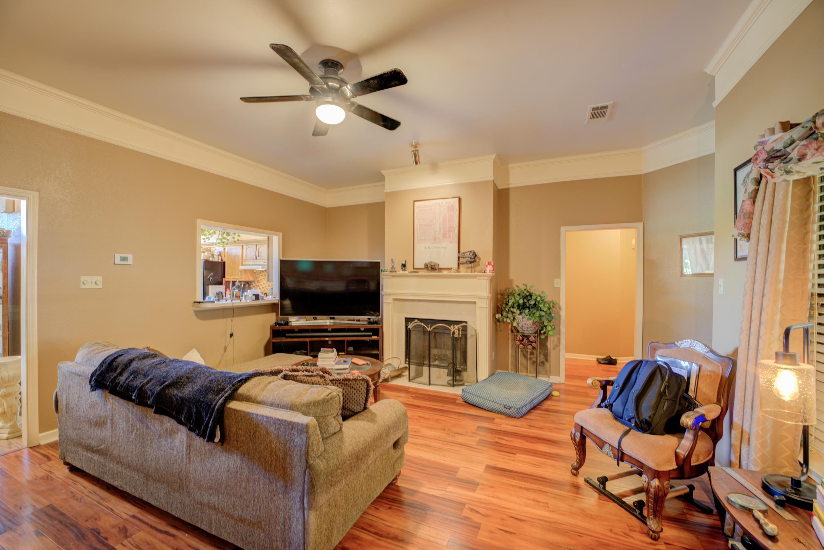 5382 Ross Road Memphis, TN 38141 - Photo 8 of 27 Living area with crown molding, a fireplace, light wood-style flooring, a ceiling fan, and visible vents
