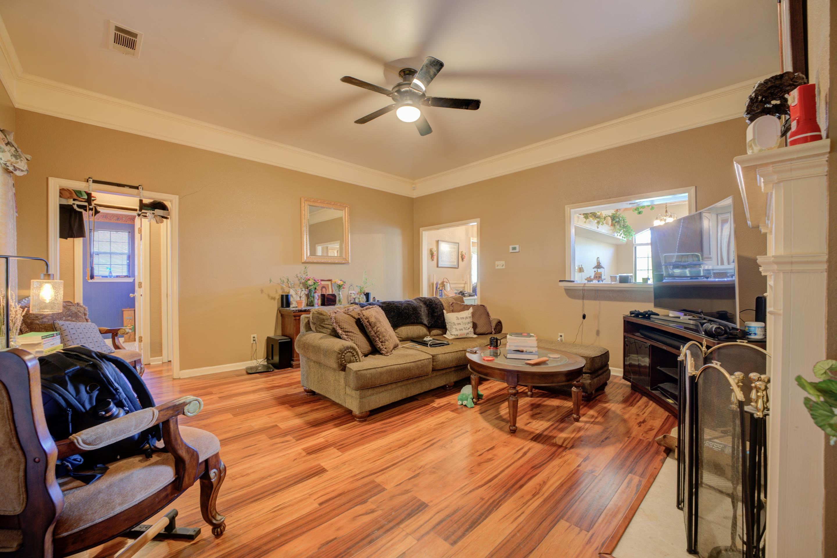 5382 Ross Road Memphis, TN 38141 - Photo 10 of 27 Living area with ceiling fan, ornamental molding, visible vents, light wood finished floors, and baseboards