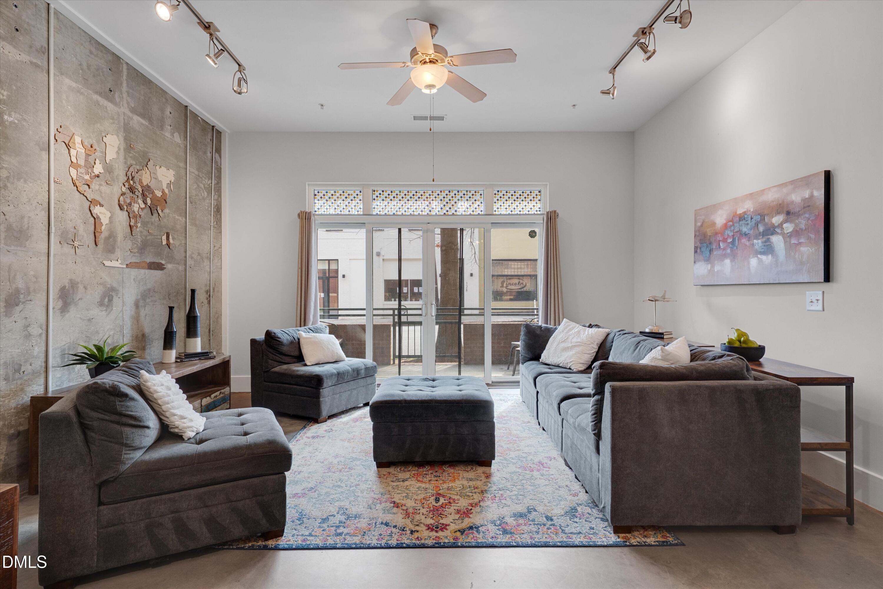 a living room with furniture and large windows