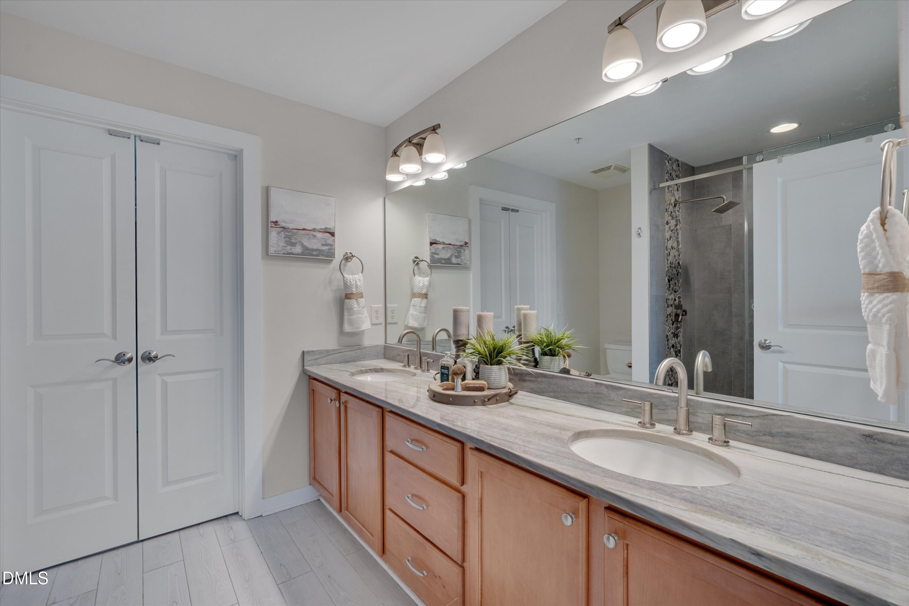 444 South Blount Street, Unit 120 Raleigh, NC 27601 - Photo 9 of 29 a bathroom with double vanity sinks and a mirror