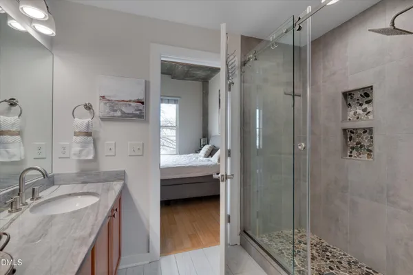 a en suite bathroom with a granite countertop sink mirror and shower