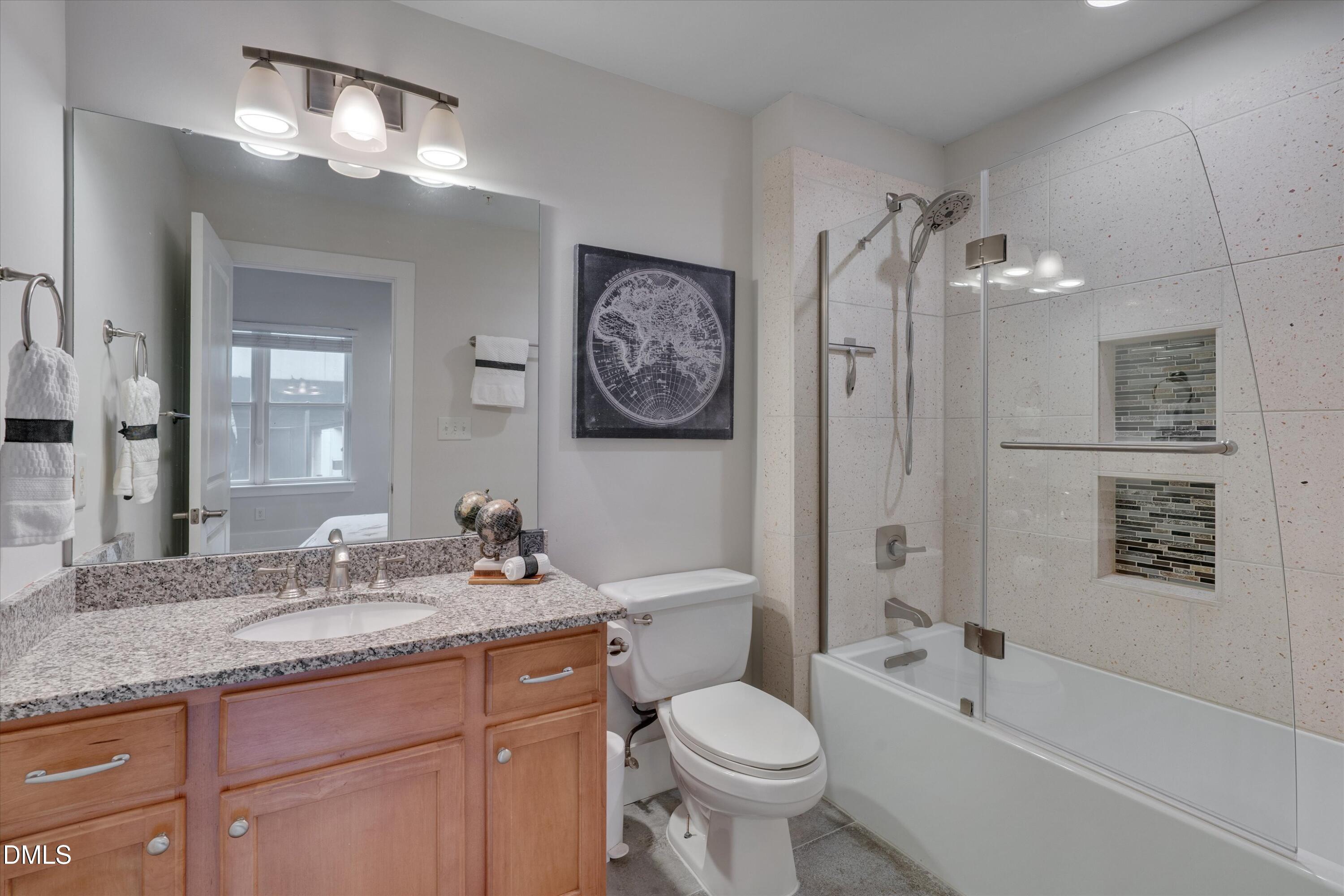 444 South Blount Street, Unit 120 Raleigh, NC 27601 - Photo 12 of 29 a bathroom with a toilet a sink a mirror a bathtub and vanity