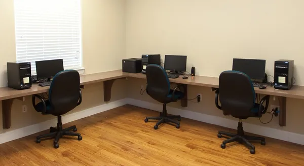 a view of a workspace with furniture and a window