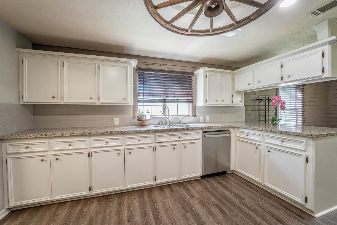 12049 Clark Lane Conroe, TX 77385 - Photo 12 of 40 a kitchen with granite countertop white cabinets a sink and dishwasher