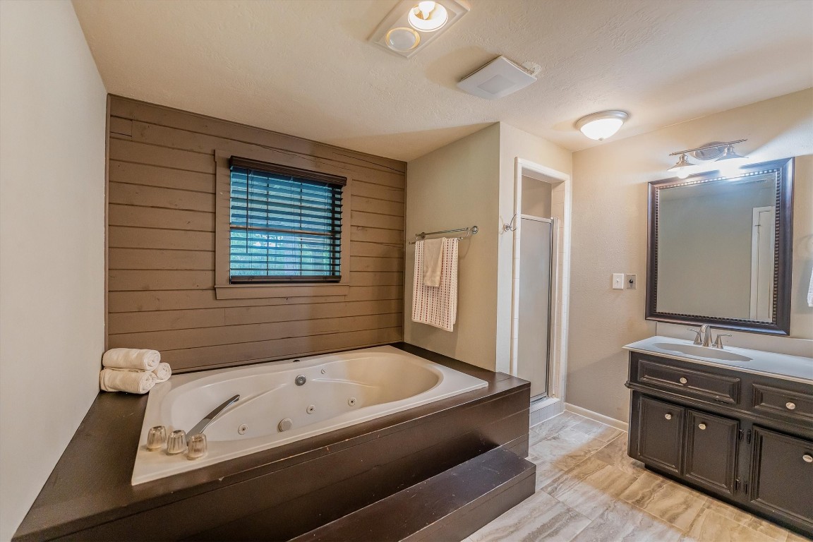 12049 Clark Lane Conroe, TX 77385 - Photo 23 of 40 a bathroom with a tub sink and mirror