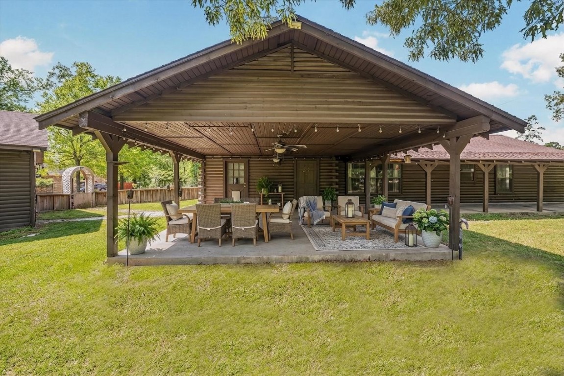 12049 Clark Lane Conroe, TX 77385 - Photo 24 of 40 a view of a patio with a dining table and chairs under an umbrella