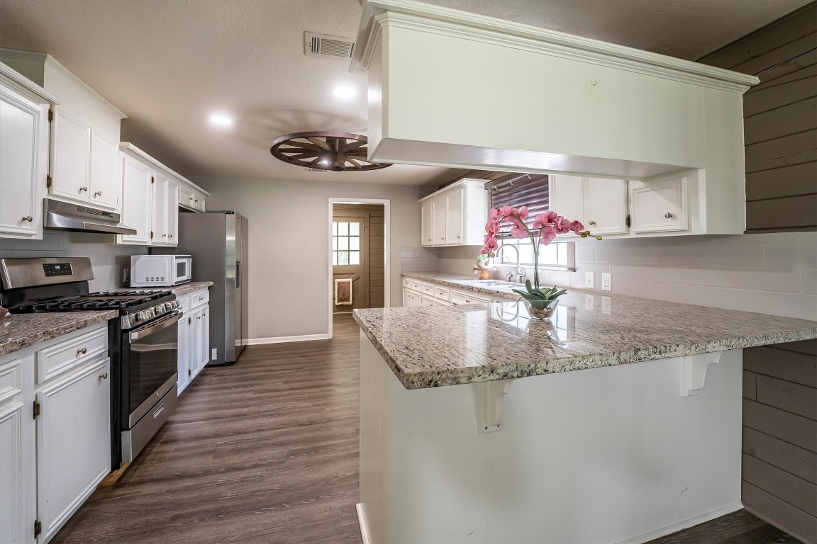 12049 Clark Lane Conroe, TX 77385 - Photo 9 of 40 a kitchen with stainless steel appliances granite countertop a sink stove and cabinets