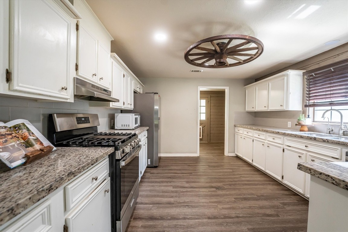12049 Clark Lane Conroe, TX 77385 - Photo 10 of 40 a large kitchen with stainless steel appliances granite countertop a stove and a sink
