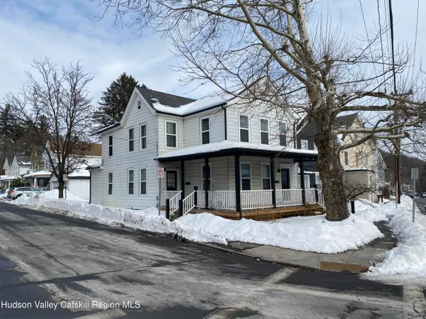 a front view of a house with a yard covered with snow