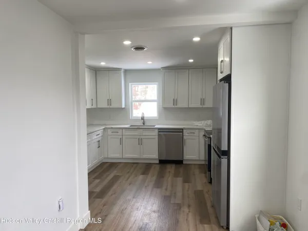 a kitchen with a white wooden cabinets and white appliances