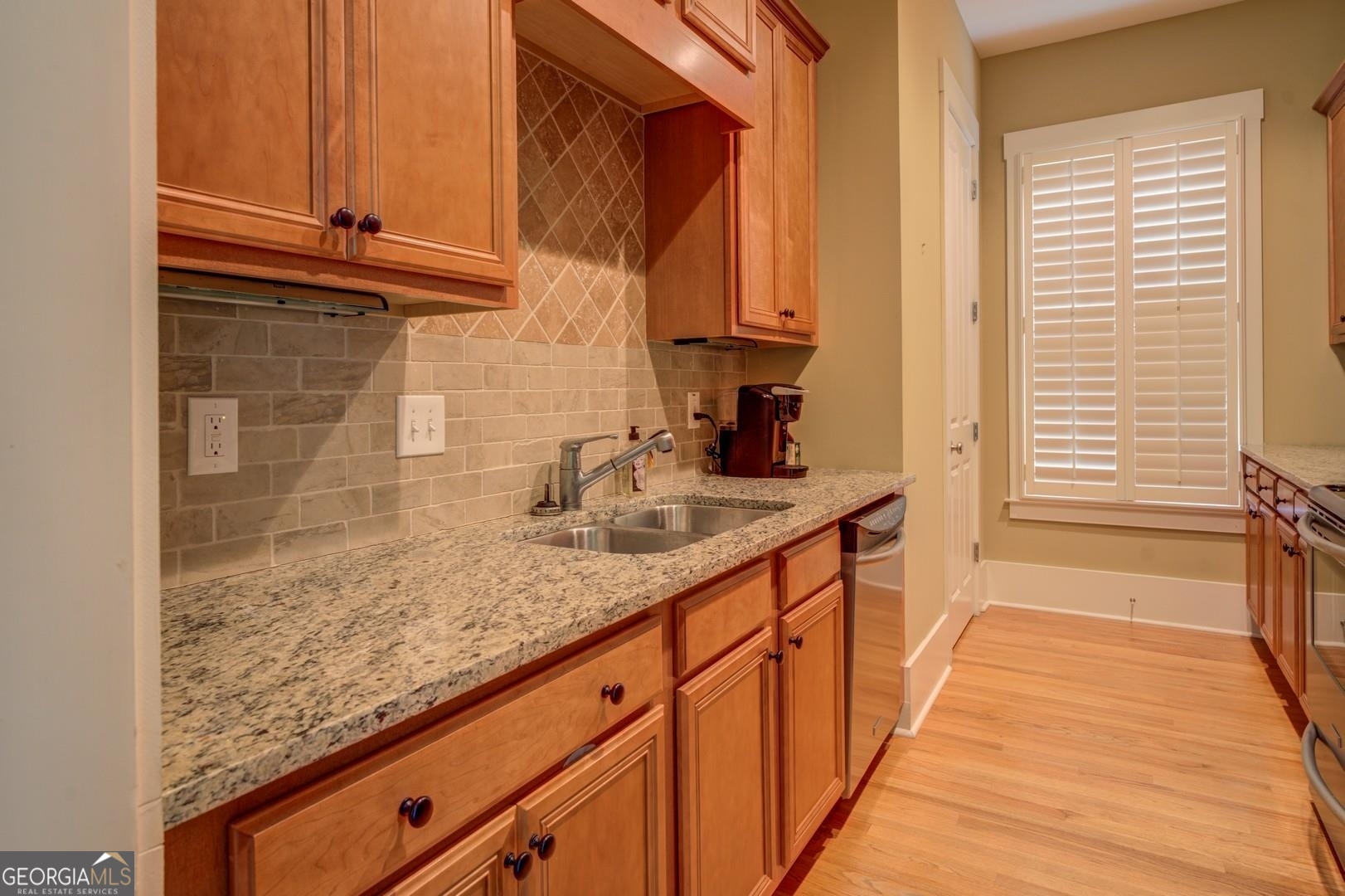 4165 Raphael Street Covington, GA 30014 - Photo 18 of 25 a kitchen with granite countertop sink and cabinets