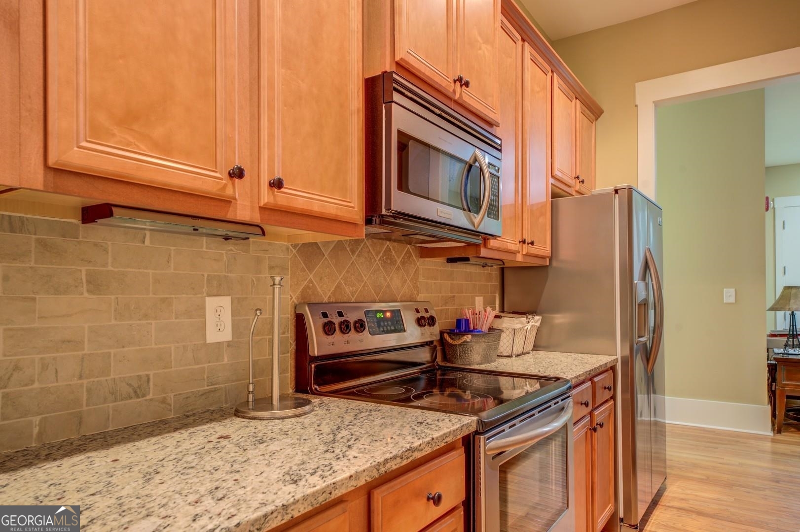 4165 Raphael Street Covington, GA 30014 - Photo 19 of 25 a kitchen with granite countertop a sink stove and refrigerator