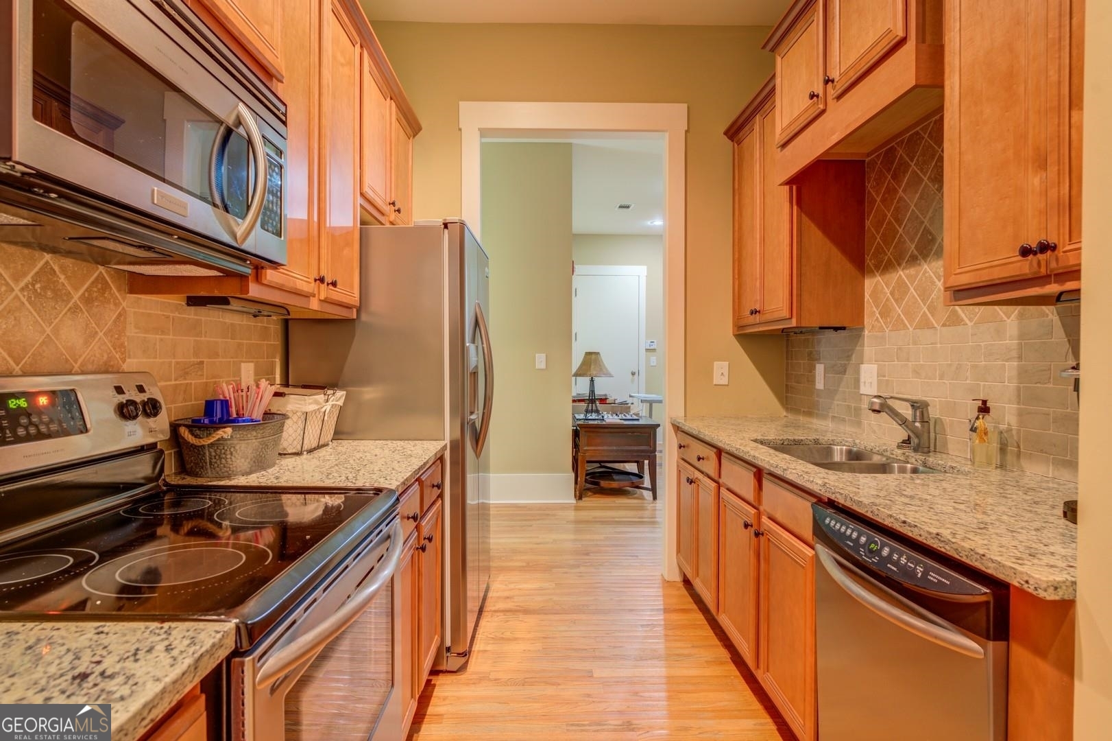 4165 Raphael Street Covington, GA 30014 - Photo 20 of 25 a kitchen with granite countertop a sink stove and cabinets