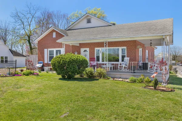 a view of a house with a big yard and potted plants