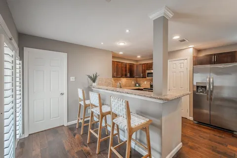 a kitchen with stainless steel appliances kitchen island granite countertop a refrigerator and a stove top oven