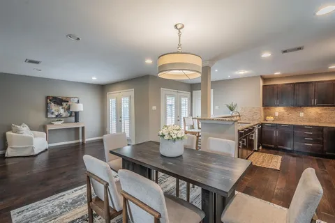 a view of a dining room with furniture a chandelier and wooden floor