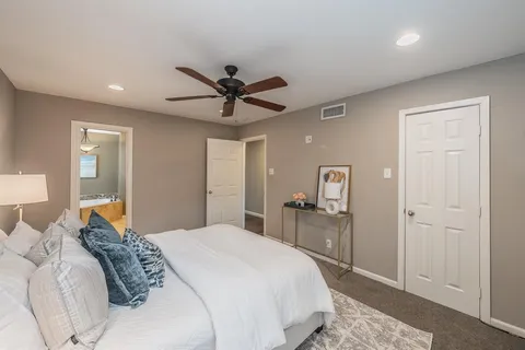 a bedroom with a large bed and a chandelier
