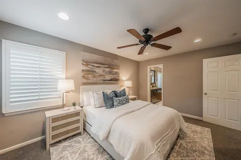 a bedroom with a bed and a ceiling fan
