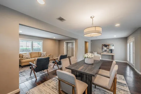 a view of a dining room with furniture a chandelier and wooden floor