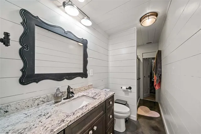 a bathroom with a granite countertop sink toilet and shower