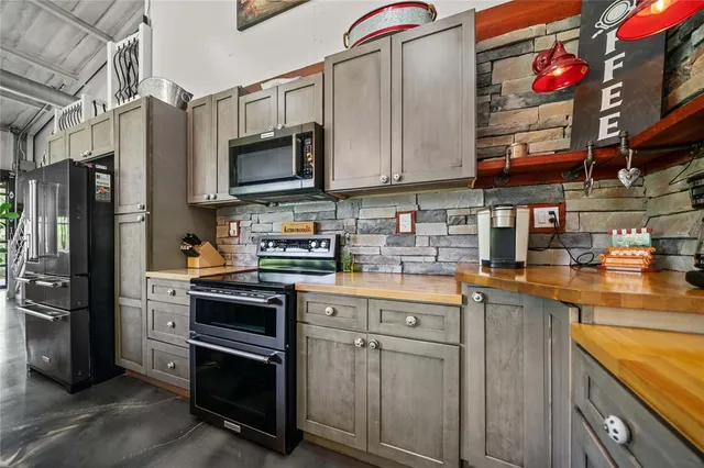 a kitchen with stainless steel appliances granite countertop a refrigerator and a stove top oven