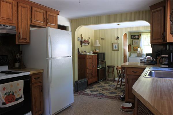 253 Lincoln Road Lincoln, MA 01773 - Photo 13 of 14 a kitchen with stainless steel appliances granite countertop a refrigerator a stove and a sink with wooden cabinets