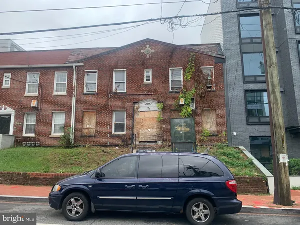 a car parked in front of a brick house