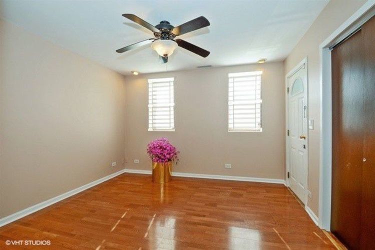 1631 West 18th Street, Unit 2 Chicago, IL 60608 - Photo 5 of 7 a view of an empty room with a chandelier fan and wooden floor