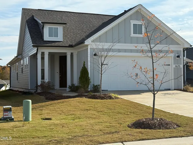 a kitchen with stainless steel appliances granite countertop a stove top oven a sink a dining table and chairs with wooden floor