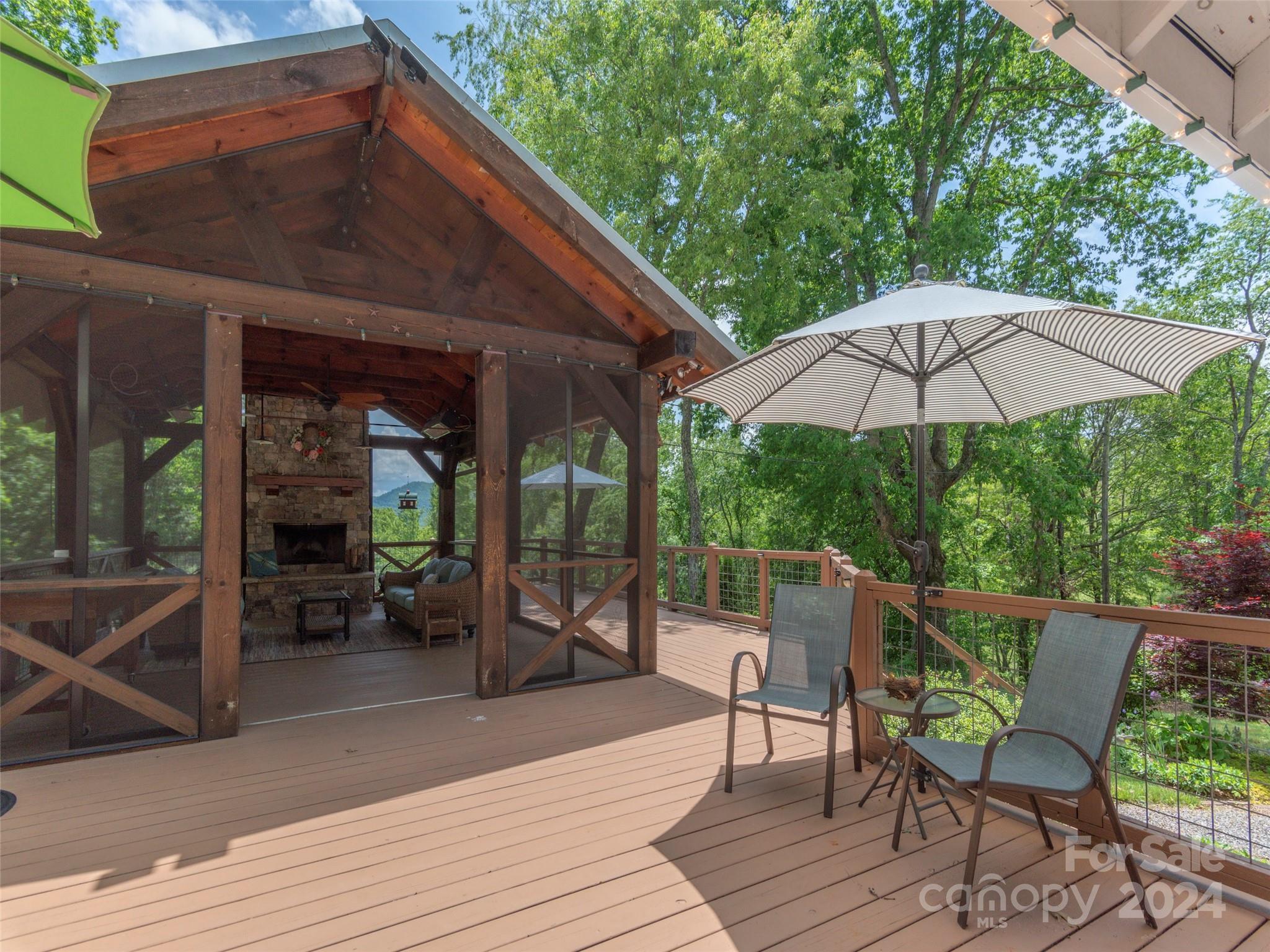 952 Thompson Cove Road Clyde, NC 28721 - Photo 3 of 43 a patio with wooden floor a yard a table and chairs