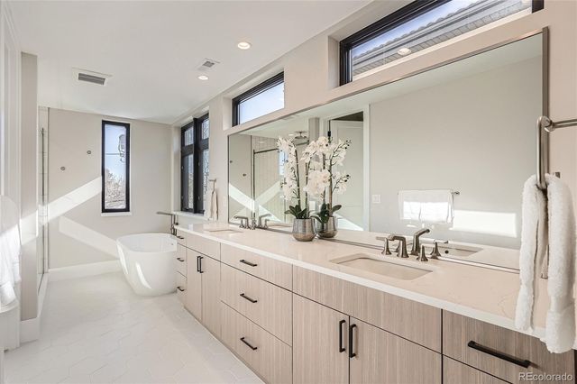 a spacious bathroom with a double vanity sink mirror and bathtub