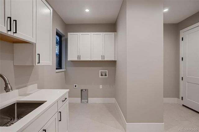 a kitchen with white cabinets and sink